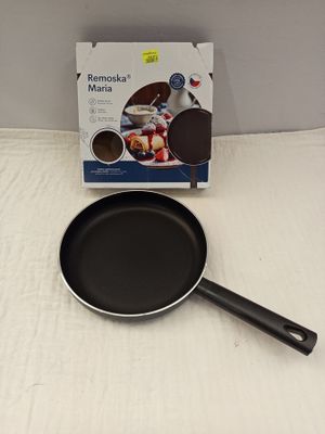 une poêle noire posée sur une table blanche