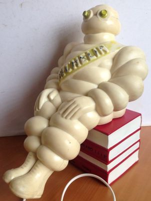 a statue of a man sitting on top of a stack of books