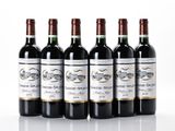 six bottles of wine are lined up on a white surface