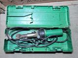a green box with a drill in it sitting on the floor