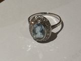 a close up of a ring with a blue topaz stone on it
