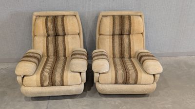 pair of mid century style lounge chairs with striped upholstered cushions
