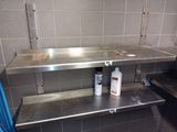 a metal shelf with a bottle of cleaner on top of it