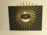 un motif « sunburst » noir et doré orné d'un miroir