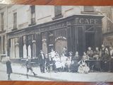 an old photo of a group of people in front of a cafe