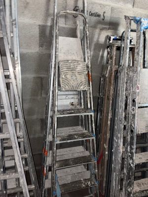 de nombreuses échelles appuyées contre un mur dans une pièce
