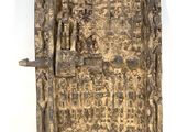 un vieux livre écrit posé sur une surface blanche