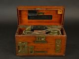 a small wooden box with a cord in it