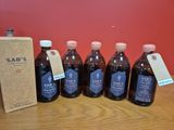 six bouteilles de sirop posées sur une table à côté d'une boîte