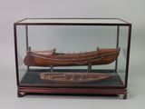 une maquette en bois d'un bateau exposée dans une vitrine