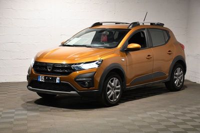 la voiture orange est garée dans le garage sur un sol en damier