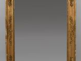un miroir à cadre doré orné d'un motif décoratif sur le pourtour
