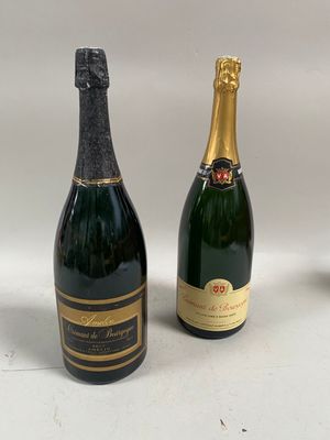 deux bouteilles de champagne et un verre de vin posés sur une table