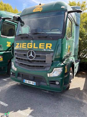 deux camions verts garés l'un à côté de l'autre sur un parking