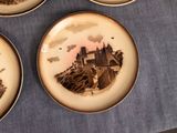 three plates with a picture of a castle on them on a table