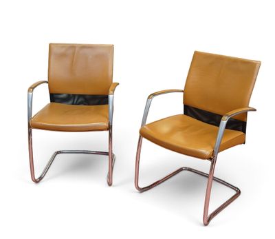 deux chaises en cuir marron assises l'une à côté de l'autre sur une surface blanche