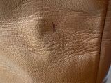 the back of a woman ' s tan leather dress on a mannequin mannequin mannequin mannequin mannequin mannequin manne
