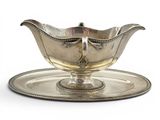 an antique silver plate with a saucer on it on a white background