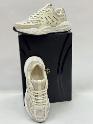 a pair of white sneakers sitting on top of a black box
