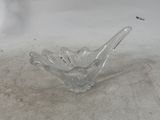 clear glass bowl sitting on a white surface with a light in the background