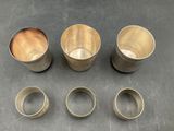four different sizes of metal cups on a table