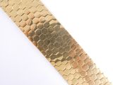 a close up of a gold bracelet on a white surface