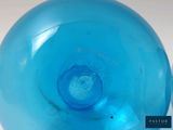 a blue glass vase with a hole in the middle