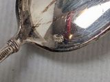 a silver spoon with a red handle on a table