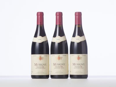 three bottles of red wine are lined up on a table