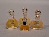 three small bottles of perfume sitting next to each other on a table