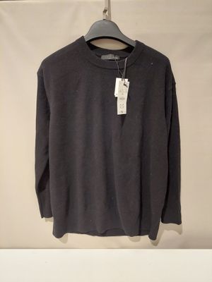 the sweater is hanging on a hanger on the wall