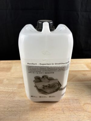 une bouteille de liquide posée sur une table à côté d'une autre bouteille de liquide
