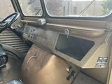 an old truck with a steering wheel and a window