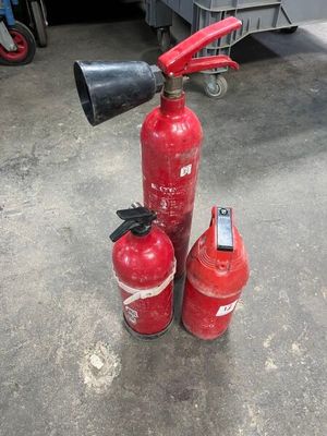 three fire extinguisors sitting on the ground next to each other