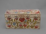 an old wooden box with painted flowers and leaves on it