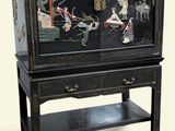 a black cabinet with a painting on it and a shelf
