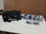 a small printer sitting on a table next to a bunch of batteries