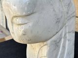 a close up of a sculpture of a person ' s head on a table