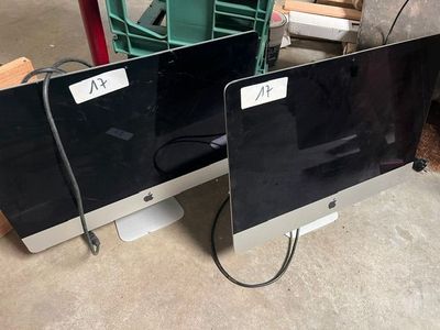 two computer monitors sitting next to each other on the floor