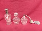 three glass vases and a pipe are sitting on a red cloth