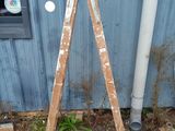 a wooden ladder leaning against a blue building