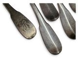 several spoons with a monogram on them sitting next to each other