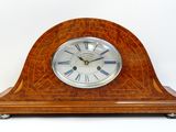 une horloge en bois posée sur une surface blanche