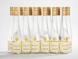 six bouteilles de vin sont alignées sur une surface blanche