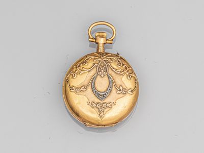 une montre de poche en or antique avec une chaîne, posée sur une surface blanche