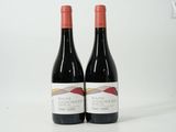 deux bouteilles de vin rouge posées l'une à côté de l'autre sur une surface blanche