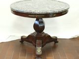 une table au plateau en marbre posée sur un sol en briques