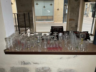 de nombreux verres vides posés sur un comptoir dans une pièce