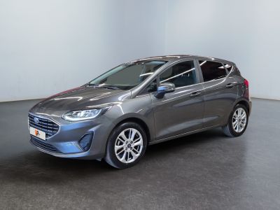 a grey car is parked in a room with a white wall