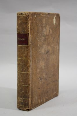 an old book sitting on top of a white table next to a white wall